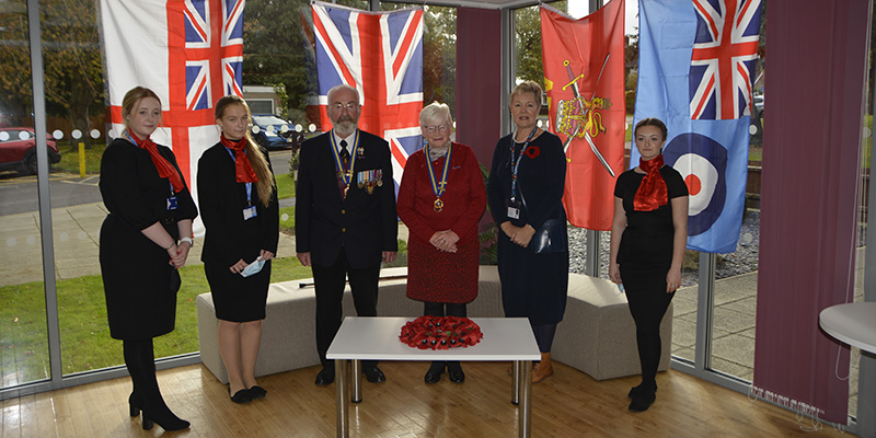 Students, veterans and volunteers with display of flags and poppies