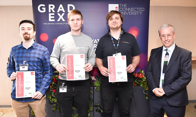 Three students holding certificates standing next to General Manager at Makita.