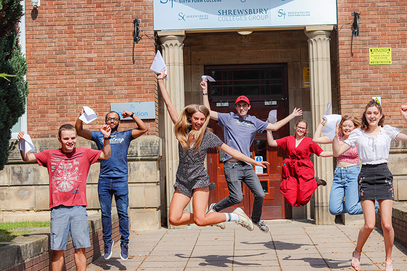 Students with exam results outside college building