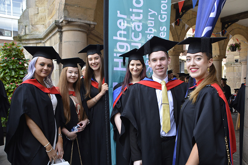 SCG Performing Arts students holding a college banner at their graduation ceremony