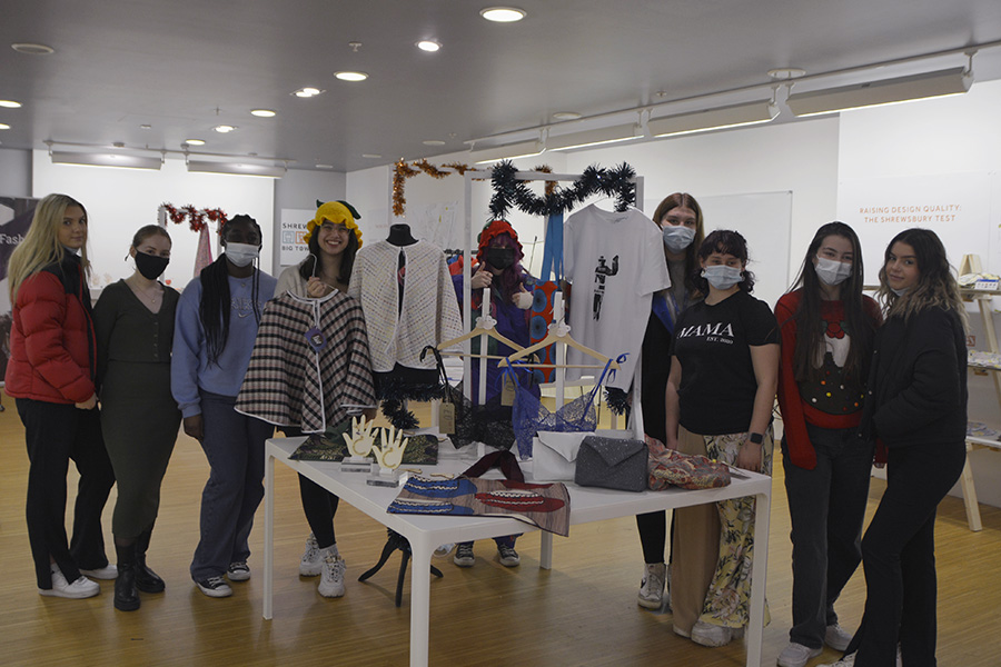 A class of Fashion & Textiles students with the items on display in their pop-up shop