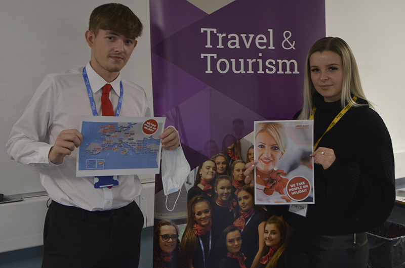 Travel & Tourism students holding up pages from their Jet2 welcome pack