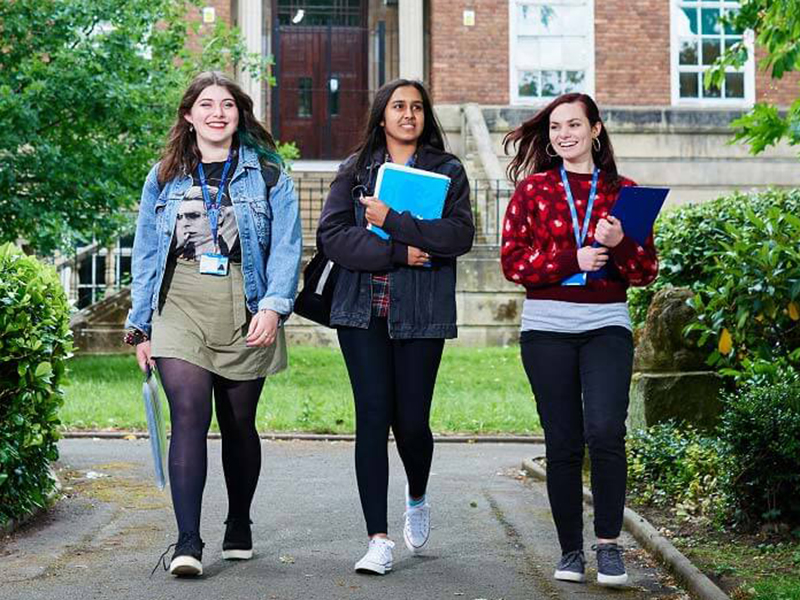 Three female students walking in the college grounds