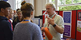 A member of The Agency team talking to students