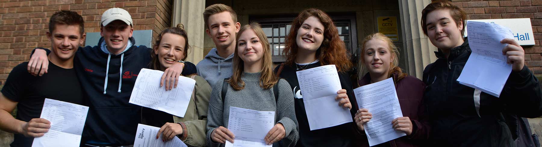 A big group of students holding their exam results