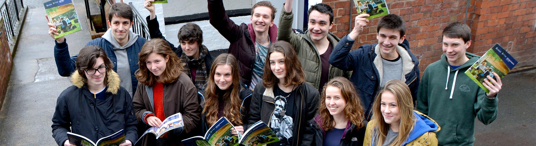 A group of students holding prospectuses
