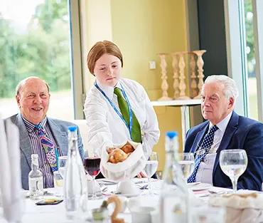 Student serving customers in college restaurant