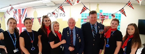 A group of travel and tourism students standing with two veterans. 