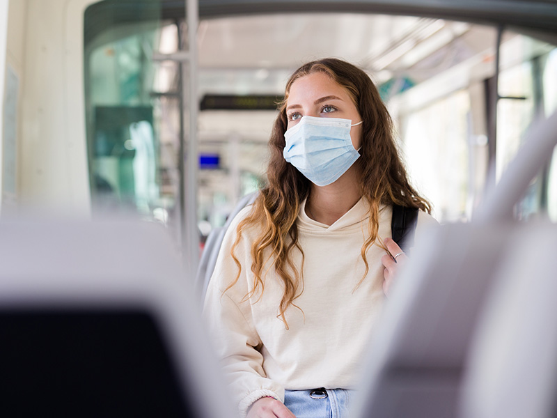 Student wearing facemask on bus