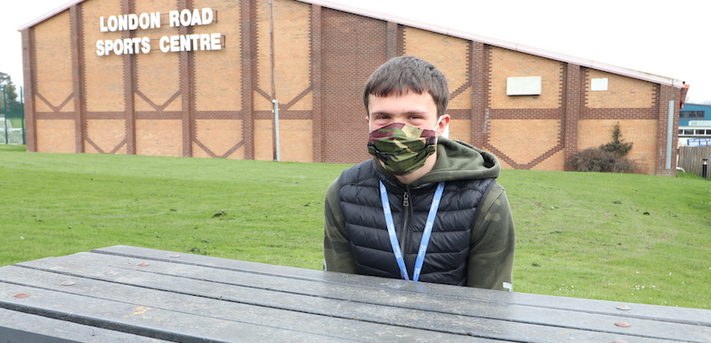 Student wearing mask outside College building