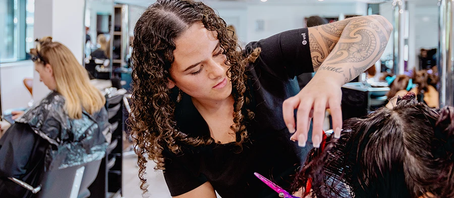 Student applying nail polish to client