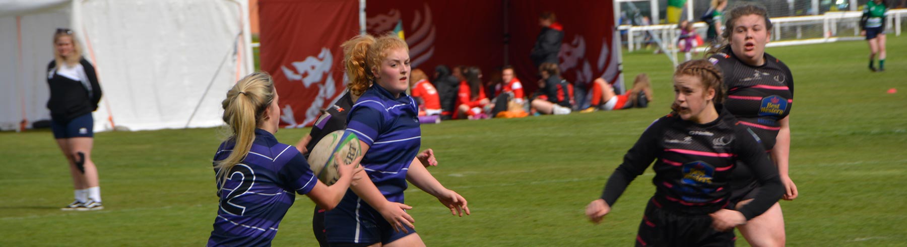 A mixed group of students playing rugby